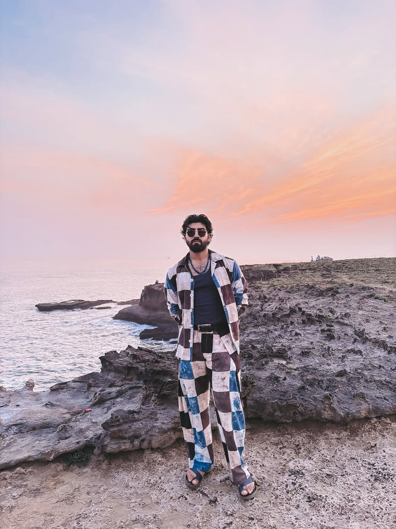 Man wearing layer style clothing on a beach 